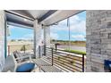 Inviting front porch showcasing stone columns and wrought-iron railing, providing a scenic view at 5567 Moosehead Cir, Longmont, CO 80503