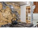 Kitchen with stone backsplash, pot filler, stainless appliances, and built-in wooden pull-out shelves at 6723 Perry Park Blvd, Larkspur, CO 80118