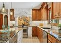 Gourmet kitchen featuring custom cabinetry, granite countertops, and stainless steel appliances at 6723 Perry Park Blvd, Larkspur, CO 80118