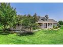 Charming single-Gathering home featuring a beautiful front porch, manicured lawn, and mature trees at 16029 W 75Th Pl, Arvada, CO 80007