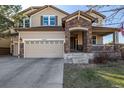 Charming home with stone accents, a manicured lawn, and a welcoming front porch at 15310 E 108Th Way, Commerce City, CO 80022