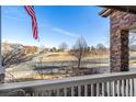 Relaxing front porch featuring stone columns, comfortable seating, and a view of the neighborhood at 15310 E 108Th Way, Commerce City, CO 80022