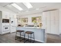 Bright kitchen boasting white cabinetry, a granite island with seating, and stainless steel appliances at 8045 S Wagon Wheel Rd, Morrison, CO 80465