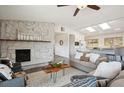 Cozy living room featuring a stone fireplace, comfortable seating, and an open layout flowing into the kitchen at 8045 S Wagon Wheel Rd, Morrison, CO 80465