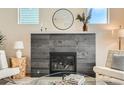 Close up of the fireplace in the living room, featuring stone detail and modern decor at 2466 S Cherokee St, Denver, CO 80223