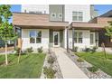 Contemporary townhome with manicured lawn, decorative rock beds, and a concrete walkway to the front door at 2466 S Cherokee St, Denver, CO 80223