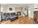 Inviting living room with stone fireplace, comfortable seating, and wood floors at 6765 S Independence St, Littleton, CO 80128
