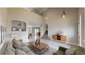 Bright and airy living room with a vaulted ceiling, neutral color palette, and tile flooring at 5308 S Ukraine St, Aurora, CO 80015