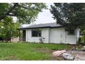 Well-maintained single-story home with white siding, manicured lawn, and updated windows for enhanced curb appeal at 5008 Alcott St, Denver, CO 80221
