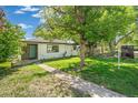 Landscaped front yard featuring mature trees and a 'For Sale' sign at 5008 Alcott St, Denver, CO 80221