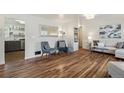 Open-concept living room features hardwood floors, neutral tones, and a view into the kitchen at 5008 Alcott St, Denver, CO 80221
