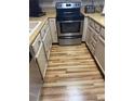 Cozy kitchen featuring wood-look floors, neutral cabinets and a stainless-steel stove at 16941 E Chenango Ave # C, Aurora, CO 80015