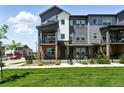 Gray townhouse exterior with a black metal fence and a green lawn at 6988 Ipswich Ct, Castle Pines, CO 80108