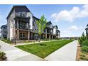 Townhouse exterior featuring gray siding, a well-manicured lawn, and a sidewalk at 6988 Ipswich Ct, Castle Pines, CO 80108