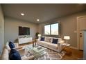 Inviting living room featuring modern decor, hardwood floors, and large window at 1705 S Yuma St, Denver, CO 80223