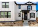 Charming two-story home featuring white siding, black trim, front porch and well-manicured landscaping at 8358 Howell St # B, Arvada, CO 80005