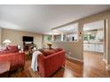 Inviting living room with hardwood floors, neutral paint, and an open view to kitchen at 6011 Welch St, Arvada, CO 80004
