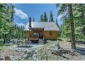 Cozy cabin exterior featuring a porch, picnic table, and peaceful wooded setting at 29 Gregory Cir, Breckenridge, CO 80424