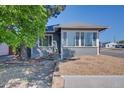 Home with river rock landscaping and a bright sunroom with lots of windows at 5723 Zephyr St, Arvada, CO 80002