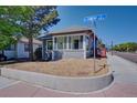 View of the home on a corner lot with well-maintained landscaping and a bright street sign at 5723 Zephyr St, Arvada, CO 80002