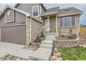 Charming two-story brick and siding home featuring an attached garage and landscaped front yard at 6610 Monaco Way, Brighton, CO 80602