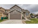 Charming two-story brick and siding home featuring an attached garage and landscaped front yard at 6610 Monaco Way, Brighton, CO 80602