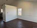 Open living area with hardwood floors and ample natural light from a large window at 6610 Monaco Way, Brighton, CO 80602
