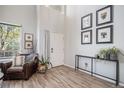 Bright entryway with wood floors, white walls, and a high ceiling, complemented by stylish furniture and decor at 6039 S Ukraine Cir, Aurora, CO 80015