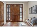 Elegant foyer with wood-look tile flooring, a stained wood door, and a cozy bench at 2975 E Wesley Ave, Denver, CO 80210