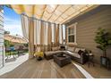 Relaxing outdoor patio featuring comfortable seating, stylish sunshades, and views of the landscaped backyard at 672 W 128Th Pl, Westminster, CO 80234