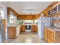 Functional kitchen with wooden cabinets, white appliances, and ample counter space at 6101 E 3Rd Ave, Denver, CO 80220