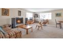 Spacious living room with a fireplace, plush carpeting, and an array of stylish mid-century modern furniture at 6101 E 3Rd Ave, Denver, CO 80220
