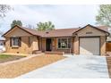 Lovely ranch-style home boasts a brick exterior, large picture window, and attached garage at 4250 Marshall St, Wheat Ridge, CO 80033