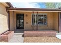 Charming front porch features brick accents and a secure entry door with an updated window at 4250 Marshall St, Wheat Ridge, CO 80033