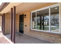 Inviting front porch with brick pillars, security door, and a large picture window at 4250 Marshall St, Wheat Ridge, CO 80033