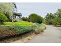 Attractive home surrounded by lush landscaping and a curving driveway at 935 Green Gables Cir, Bennett, CO 80102