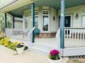 Charming covered front porch with ample seating and decorative flower pots at 935 Green Gables Cir, Bennett, CO 80102