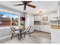 Sun-filled kitchen featuring white cabinets, modern appliances, and adjacent dining area at 159 Judson St, Longmont, CO 80501