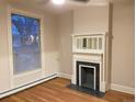 Cozy living room with a fireplace, large window, and hardwood floors, perfect for relaxation at 1767 N Washington St, Denver, CO 80203