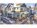 Charming townhome with light blue siding, brick accents, and snow-covered roof at 12961 Lafayette St # B, Thornton, CO 80241