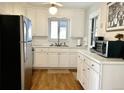 Bright kitchen featuring updated stainless steel appliances, white cabinets, and hardwood floors at 5740 S Delaware St, Littleton, CO 80120