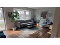 Cozy living room featuring hardwood floors, comfortable seating, and a bright bay window at 5740 S Delaware St, Littleton, CO 80120