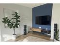 Stylish living room with a large TV, hardwood floors, and a large green plant at 5740 S Delaware St, Littleton, CO 80120