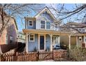 Inviting two-story home with a cozy front porch and a quaint fenced yard at 2533 Central Park Blvd, Denver, CO 80238