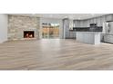 Spacious open-concept living area with modern fireplace, wood flooring, and stainless kitchen appliances at 5224 Scranton Ct, Denver, CO 80239