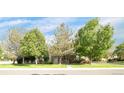 Inviting home exterior with lush green lawn and mature trees providing shade and curb appeal at 12790 Jackson St, Thornton, CO 80241