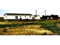 Charming ranch-style home with green, overgrown lawn and detached outbuilding at 39633 E 160Th Ave, Keenesburg, CO 80643