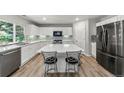 Modern kitchen with white cabinets, stainless steel appliances, large island with seating, and stylish backsplash at 21885 Whirlaway Ave, Parker, CO 80138
