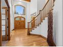 Stunning entryway showcases a wood staircase, beautiful wood floors, and a grand front door at 9303 Dauntless Way, Conifer, CO 80433