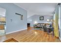 Open living room featuring vaulted ceiling and hardwood floors, with access to the kitchen at 983 S Ouray St, Aurora, CO 80017